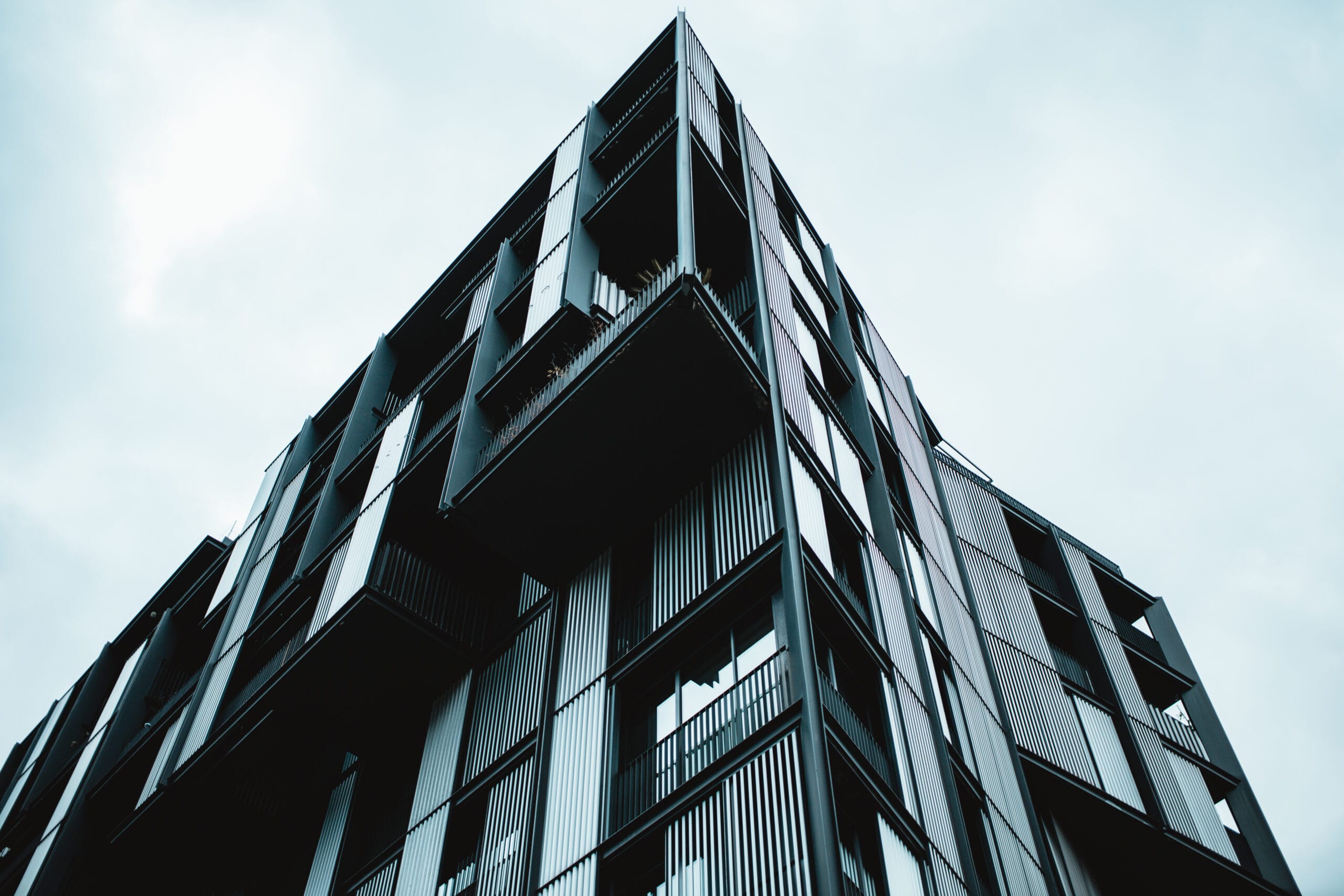 Low angle shot of a modern building with glass windows Modern glass building seen from below